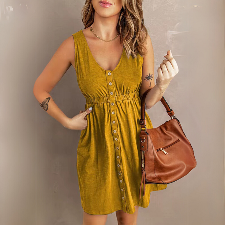 Frau in senfgelbem Sommerkleid mit Knopfleiste, hält braune Ledertasche. Mode, Damenbekleidung, Sommeroutfit, Freizeitlook.