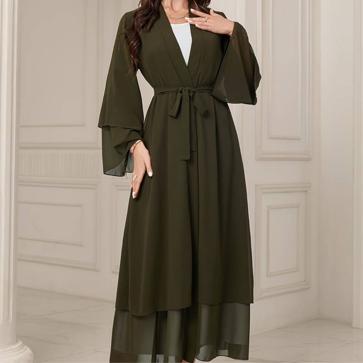 Dunkelgrüner Kimono mit Gürtel, weiten Ärmeln und fließendem Stoff, getragen von einer Frau in elegantem, klassischem Interieur.
