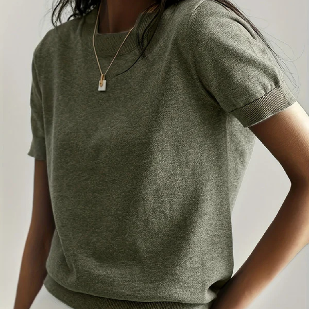 Damen T-Shirt aus grauem Baumwollstoff, kurzärmelig, mit Rundhalsausschnitt. Minimalistisches Design, ideal für lässige Mode und Sommeroutfits.