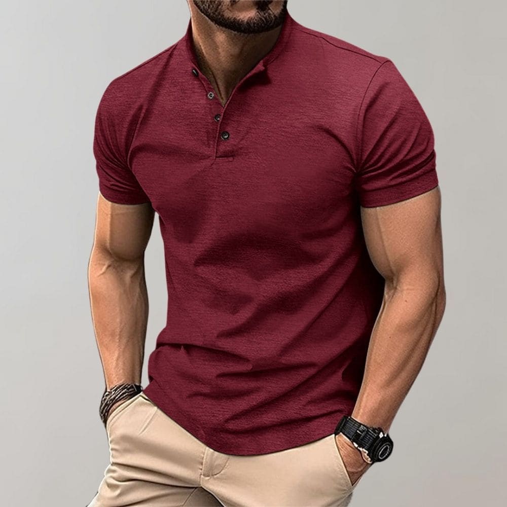Mann in rotem Poloshirt mit kurzen Ärmeln, muskulös, trägt Armbanduhr und beige Hose. Mode für Herren, lässiger Stil, Sommeroutfit.