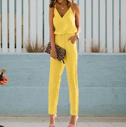Frau in gelbem Jumpsuit mit Leopardenmuster-Clutch vor blauer Wand. Sommermode, eleganter Look, trendiges Outfit, Damenbekleidung.