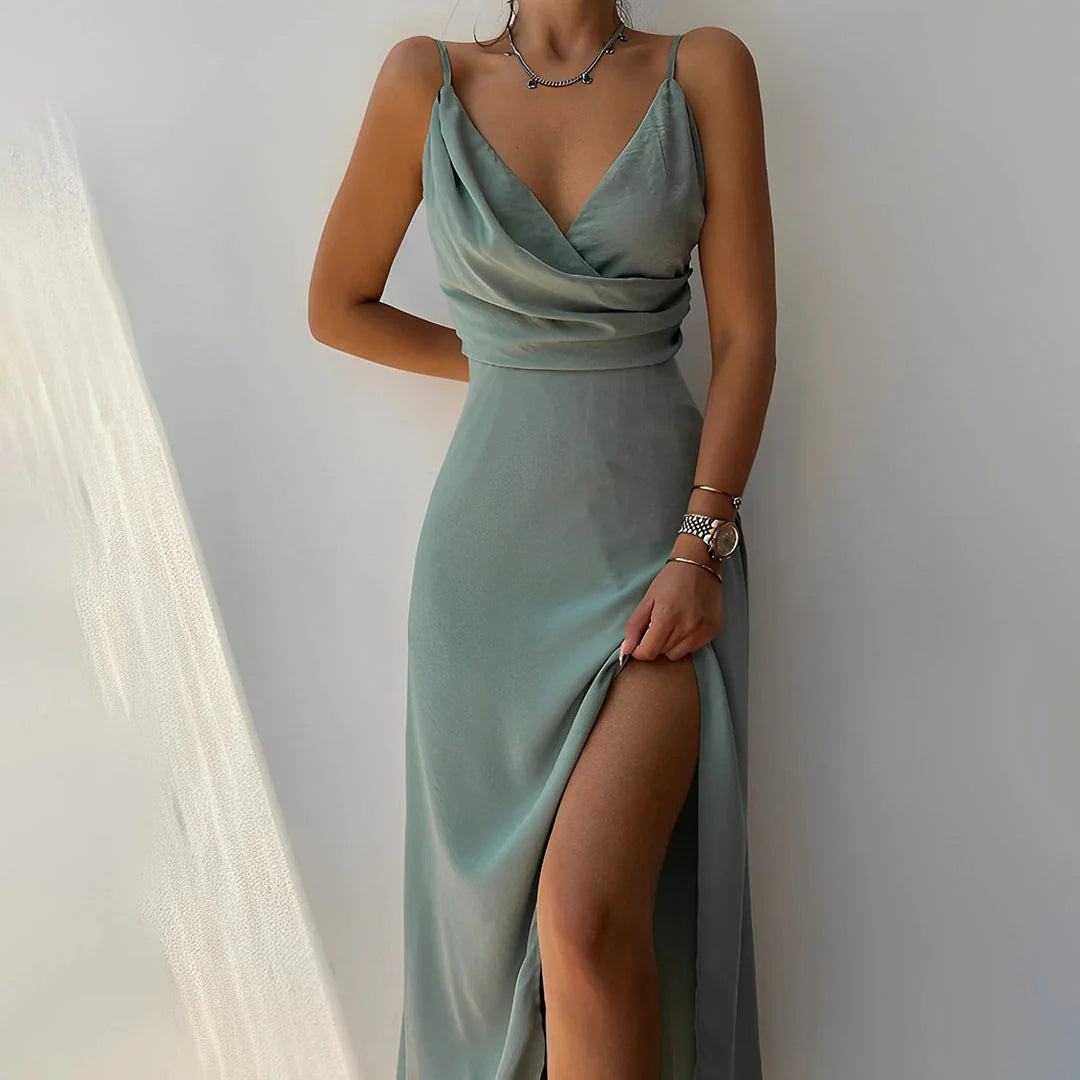 Frau in elegantem, ärmellosem, hellgrünem Abendkleid mit Beinschlitz, trägt Schmuck. Perfekt für Mode, Abendmode, Damenkleider.