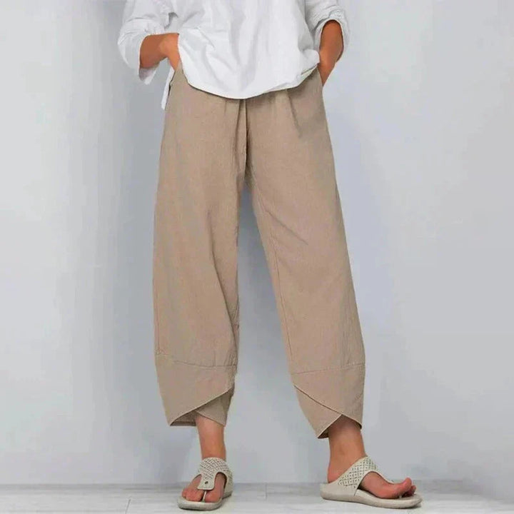 Damen in beiger Leinenhose und weißem Hemd, lässiger Look, Sommermode, bequeme Sandalen, minimalistischer Stil, entspannte Passform.
