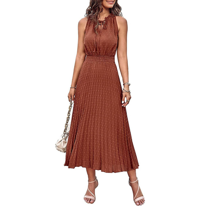 Frau in ärmellosem, braunem Midikleid mit Plissee-Design, trägt weiße Sandalen und eine Handtasche. Elegante Sommermode, Damenbekleidung.