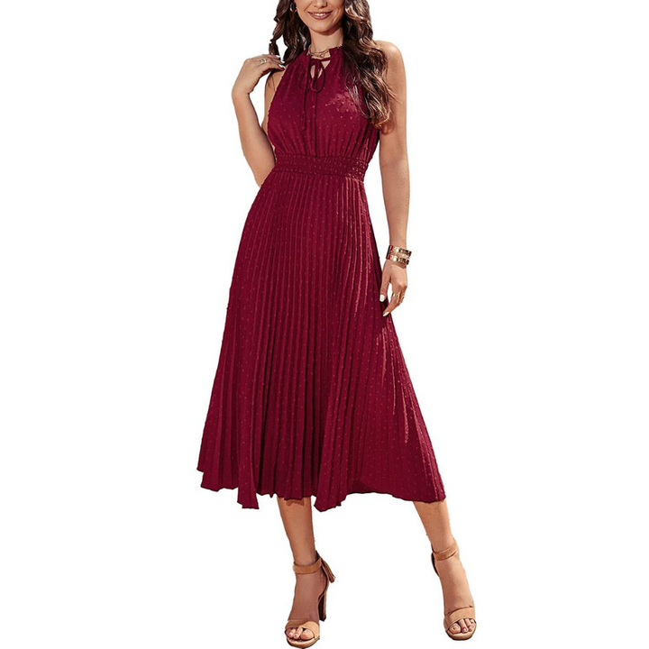 Frau in elegantem, ärmellosem, weinrotem Plisseekleid, knielang, mit Sandalen. Perfekt für Abendveranstaltungen oder festliche Anlässe.