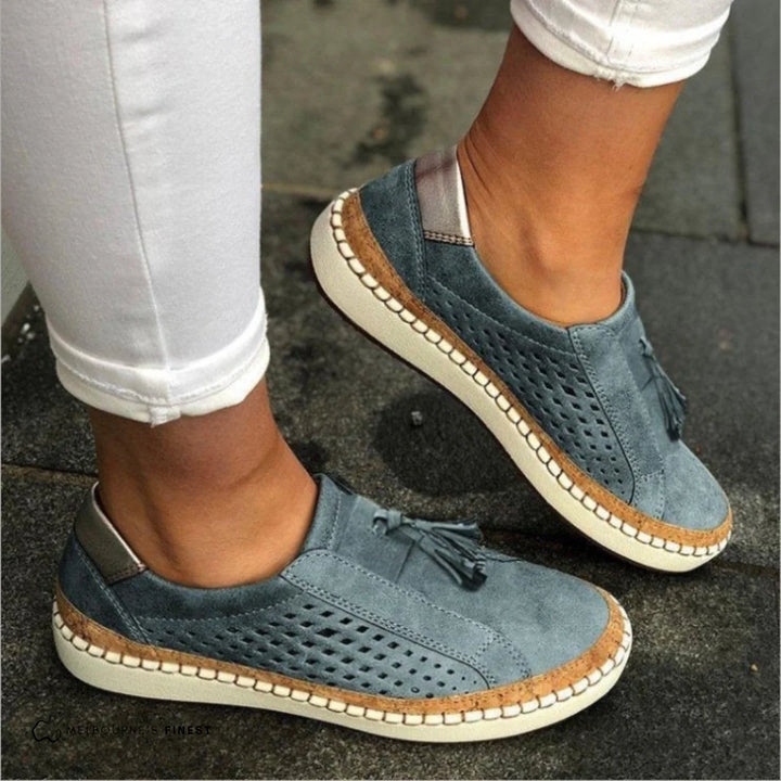Damen Sneaker in Blau mit Lochmuster und Quasten, kombiniert mit weißen Hosen. Bequeme Freizeitschuhe für den Alltag.