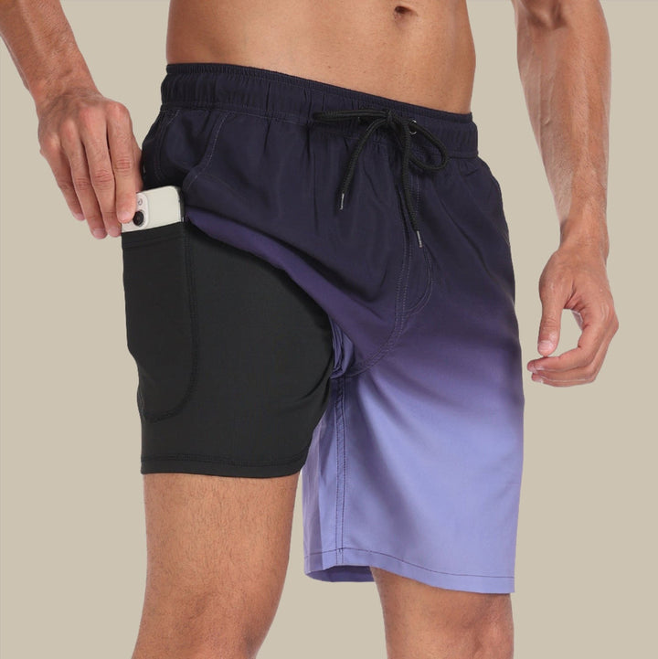 Mann in lila Badehose mit Handy in der Tasche, sportlich, modisch, Sommermode, Strandbekleidung, praktische Seitentasche, Freizeitkleidung.