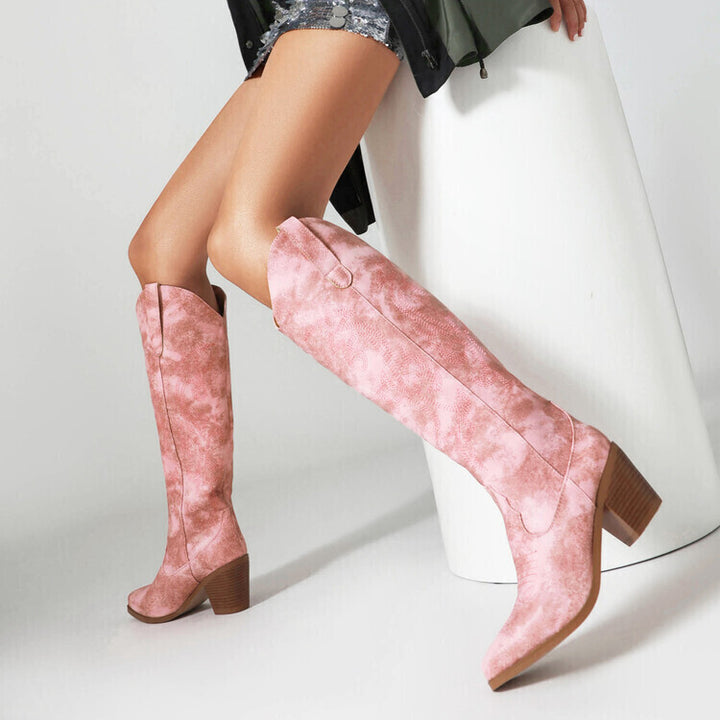 Frau trägt rosa kniehohe Stiefel mit Blockabsatz, kombiniert mit einem glitzernden Rock. Modetrend, Damenstiefel, stilvolle Herbstmode.