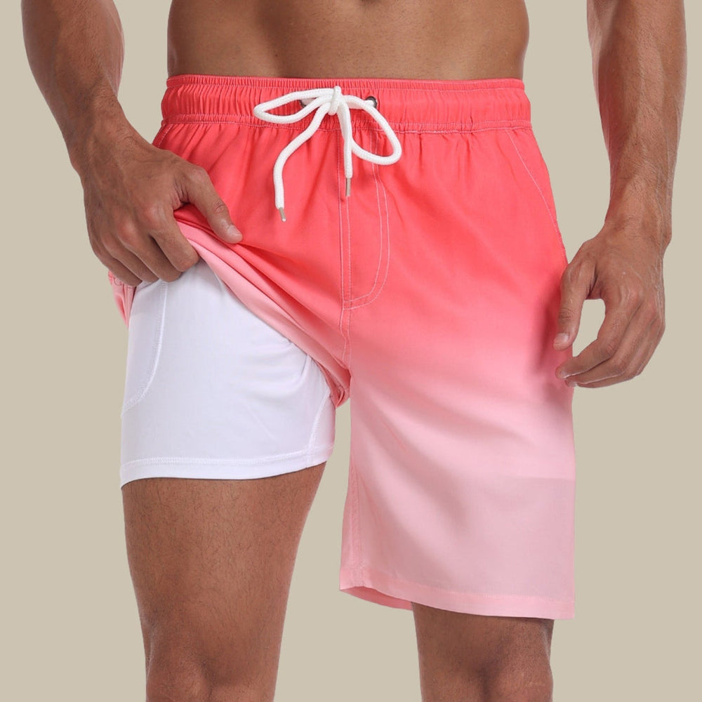 Mann trägt rosa Badeshorts mit weißem Innenfutter, zeigt elastischen Bund und Kordelzug. Sommermode, Herrenbadebekleidung, Strandoutfit.
