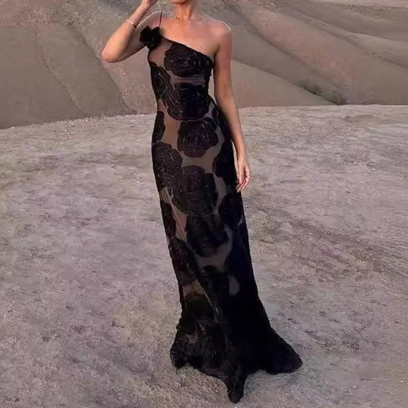 Elegantes schwarzes Abendkleid mit Blumenmuster, schulterfrei, in Wüstenlandschaft. Perfekt für formelle Anlässe und modische Events.
