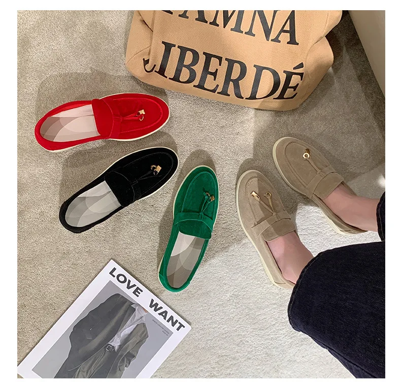 Vier Paar Mokassins in Rot, Schwarz, Grün und Beige auf Teppich neben einer Tasche und einem Magazin. Bequeme, stilvolle Schuhe für Damen.