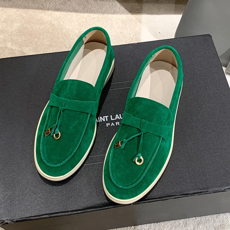 Grüne Wildleder-Loafer auf schwarzem Karton, elegante Herrenschuhe, modisches Design, hochwertige Materialien, ideal für stilvolle Anlässe.