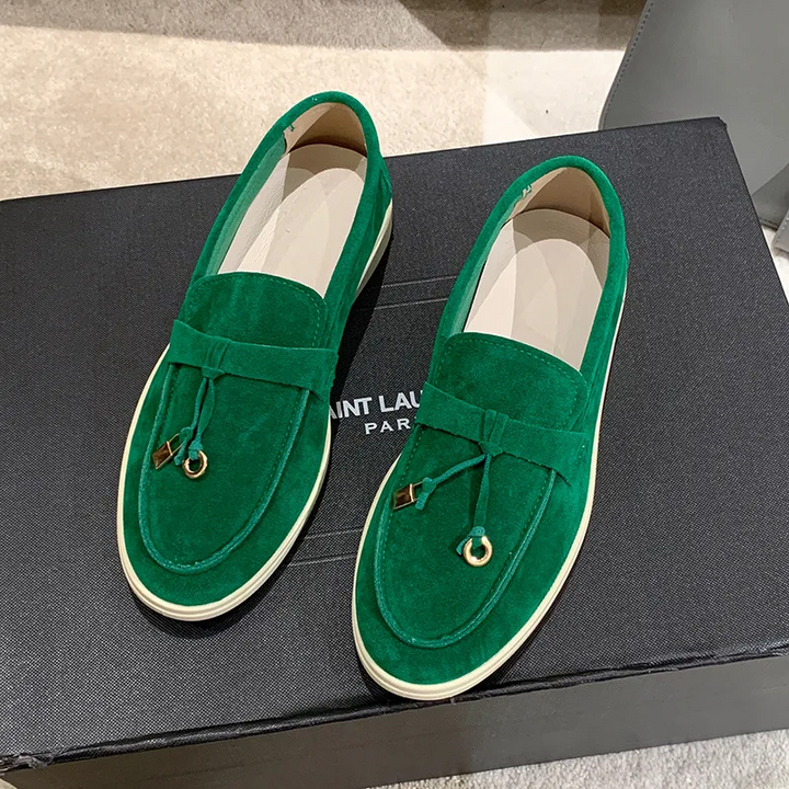 Grüne Wildleder-Loafer auf schwarzem Karton, elegante Herrenschuhe, modisches Design, hochwertige Materialien, ideal für stilvolle Anlässe.