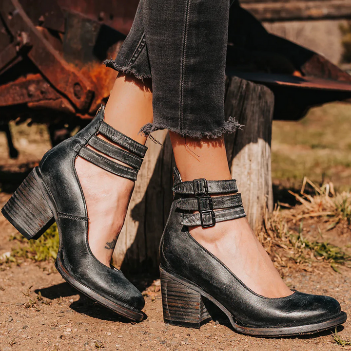 Damenstiefeletten mit Blockabsatz, schwarzes Leder, doppelte Knöchelriemen, modisch, robust, ideal für Herbstmode, Outdoor-Hintergrund.