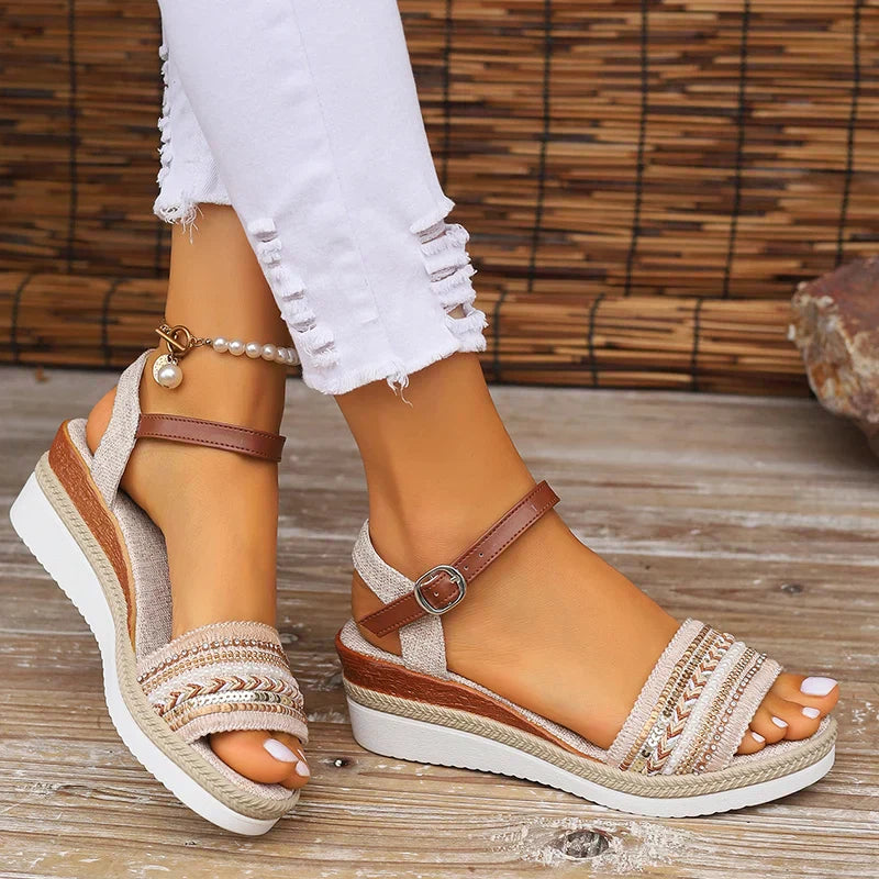 Damen Sandalen mit Keilabsatz, geflochtenem Riemen und Perlenarmband, kombiniert mit weißen Jeans. Ideal für Sommermode und Strandoutfits.