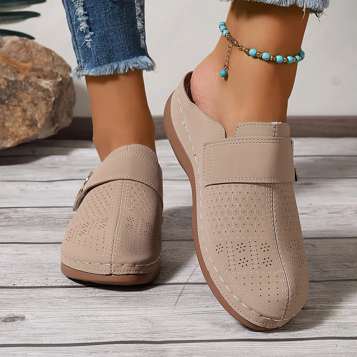 Damen Mokassins in Beige, perforiert, mit flachem Absatz. Getragen mit blauer Jeans und türkisfarbenem Fußkettchen. Ideal für Sommermode.
