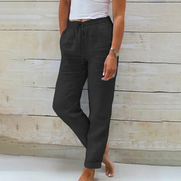 Dunkelgraue Damen-Leinenhose, lässig geschnitten, mit Kordelzug, kombiniert mit weißem Top. Perfekt für Sommermode und Freizeitoutfits.