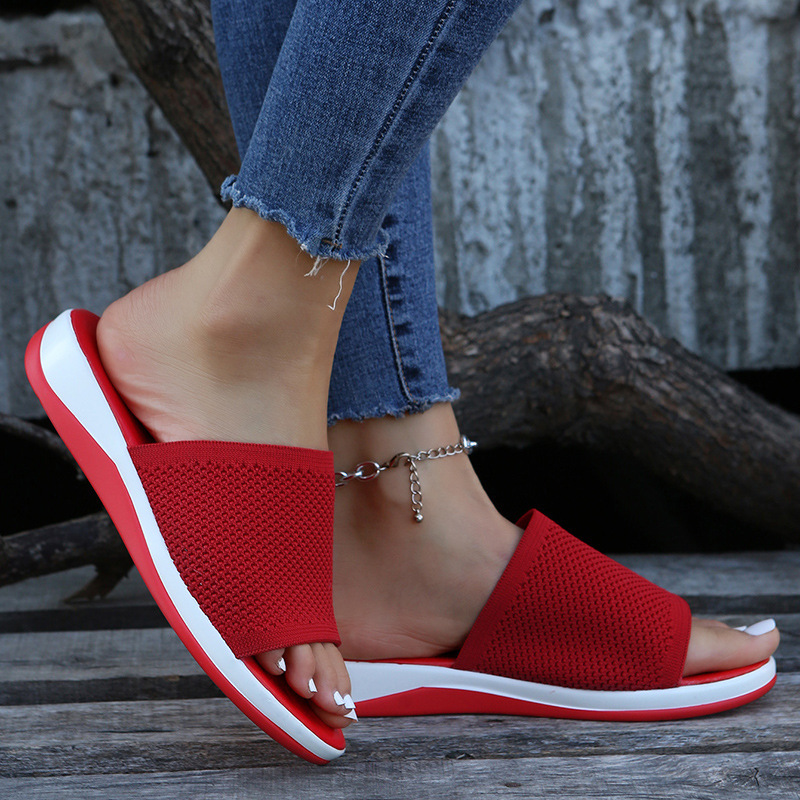 Rote Damen-Sandalen mit weißer Sohle, getragen mit blauen Jeans. Bequeme Sommerschuhe, modisch und lässig, ideal für Freizeit und Alltag.