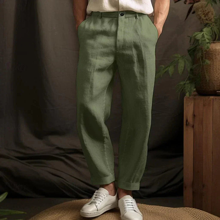 Grüne Leinenhose für Herren, kombiniert mit weißen Sneakern. Stilvolle, lässige Mode für Männer, ideal für Sommer und Freizeit.