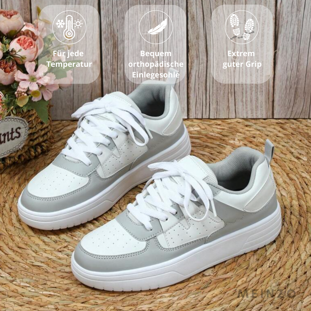Weiße und graue Sneaker mit orthopädischer Einlegesohle auf geflochtener Unterlage, dekoriert mit Blumen. Ideal für jede Temperatur, bietet extremen Grip.