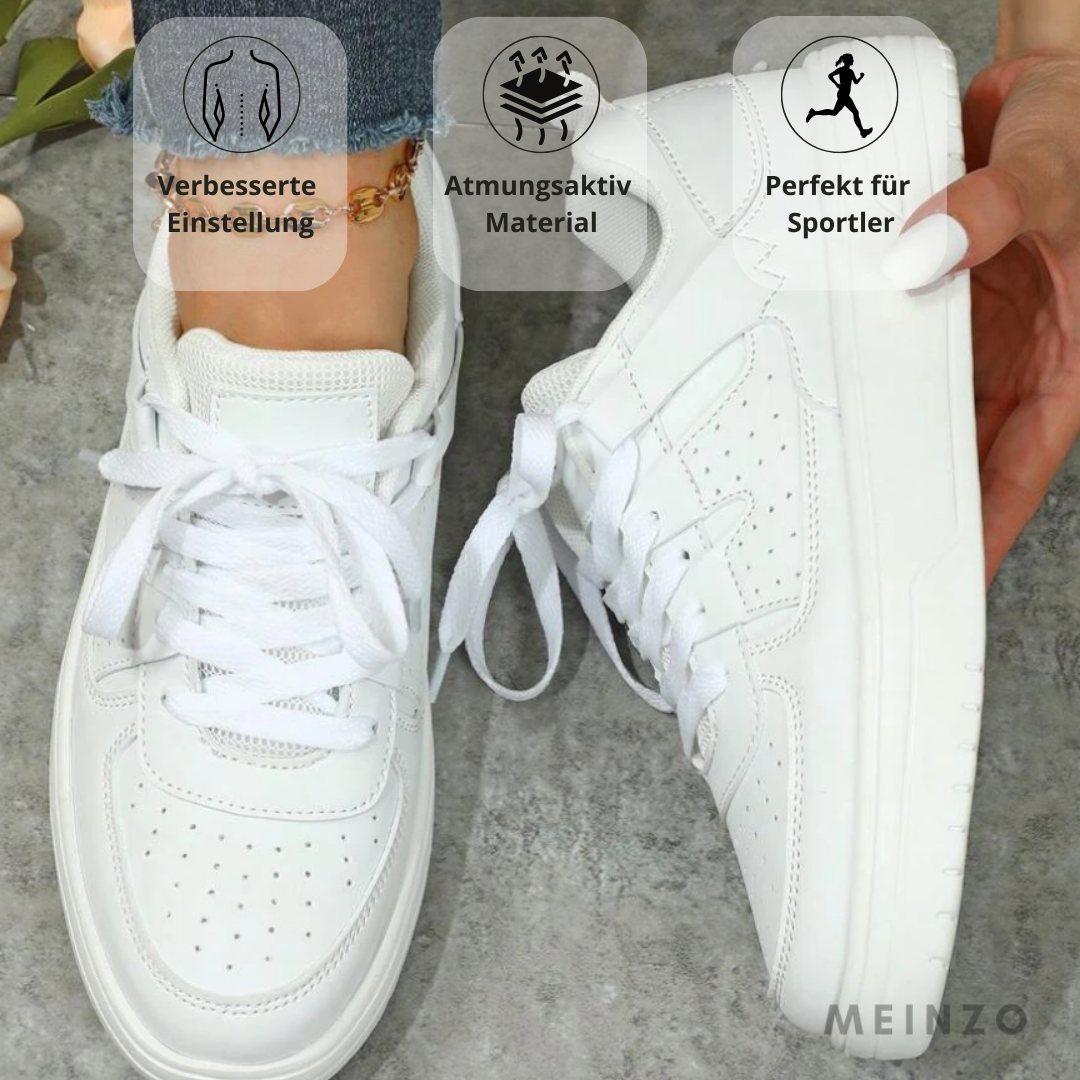 Weiße Sneaker auf grauem Boden, atmungsaktives Material, ideal für Sportler, verbesserte Passform, komfortabel und stilvoll.