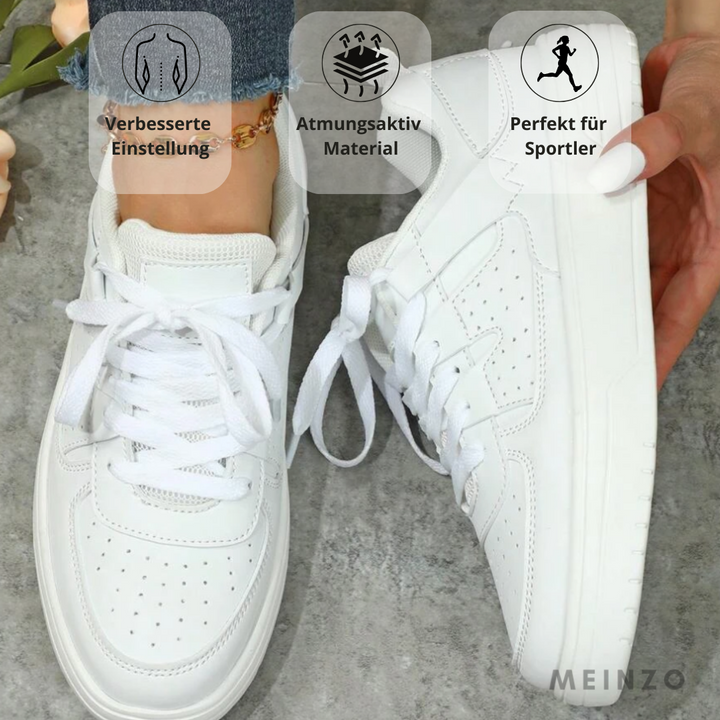 Weiße Sneaker auf grauem Boden, atmungsaktives Material, ideal für Sportler, verbesserte Passform, komfortabel und stilvoll.