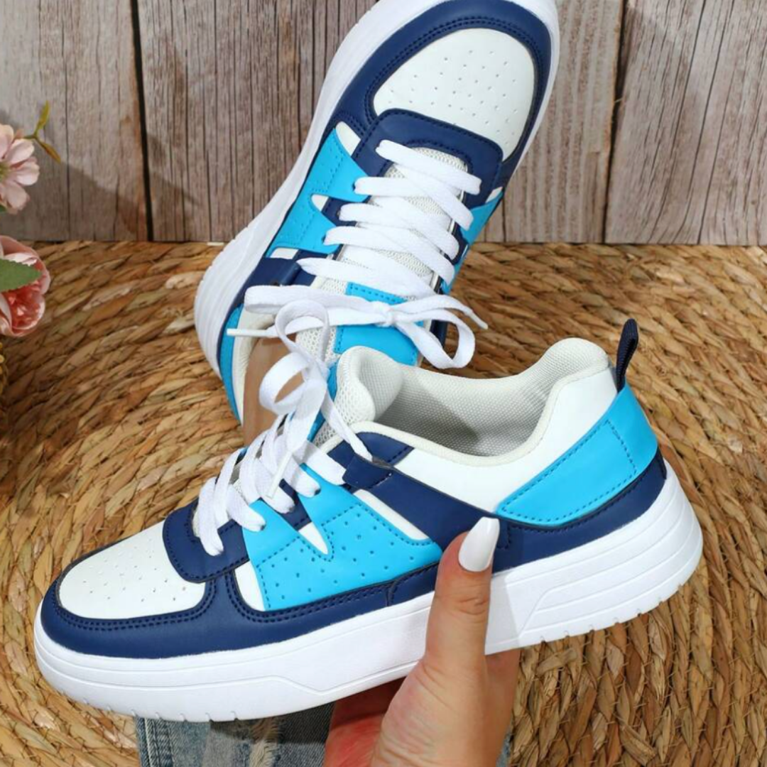 Damen-Sneaker in Blau und Weiß mit dicker Sohle, auf einem geflochtenen Teppich präsentiert. Modische Sportschuhe, ideal für Freizeit und Sport.